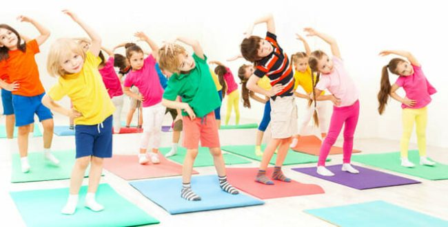 Happy kids doing side bending exercises in gym